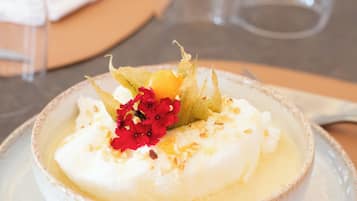 A dessert on a plate with a napkin and glasses in the background.