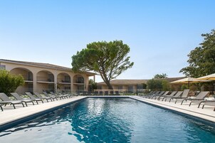 Una piscina al aire libre, sillones reclinables de piscina