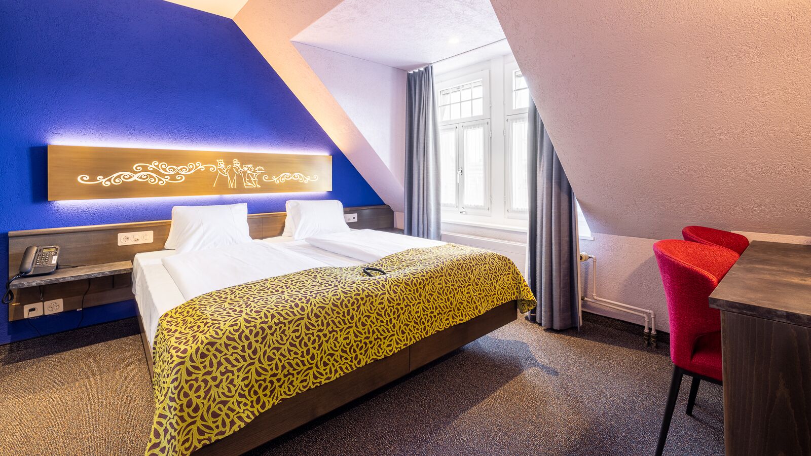 Una habitación de hotel con una cama, un escritorio y una silla.