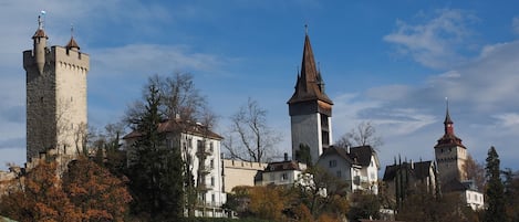 A historic town with a prominent tower and a church with a tall spire.