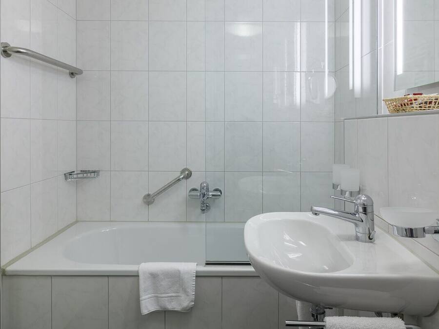 Un baño moderno con bañera, lavamanos y zona de ducha.