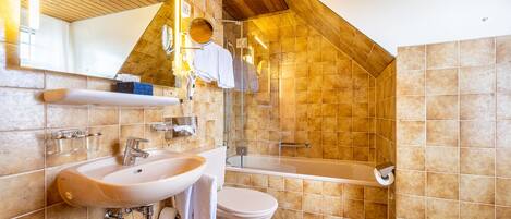 A bathroom with a sink, toilet, and shower.