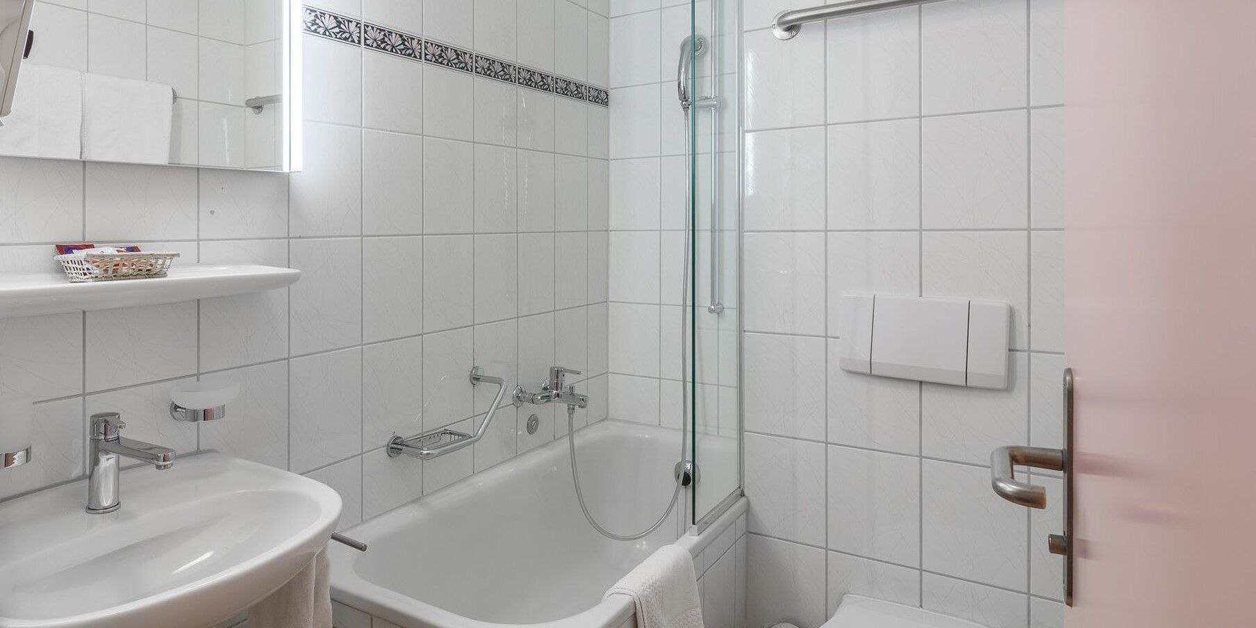 Une salle de bain moderne équipée d’une baignoire, d’une douche, d’un lavabo et de toilettes.