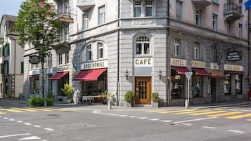 Een hoekpand met verschillende bedrijven, waaronder een café, restaurants en hotels.