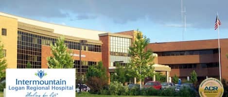 Intermountain Logan Regional Hospital with a signboard, parking area, and American flag.