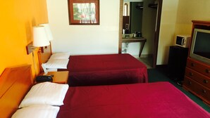 A hotel room with two beds, a desk, a television, and a mirror. - Sunrise Inn (Bradenton)