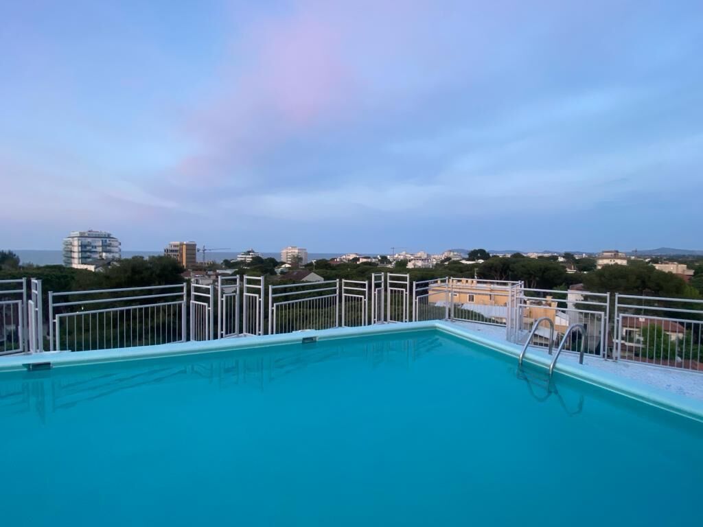 Piscina no terraço com vista para a paisagem urbana.