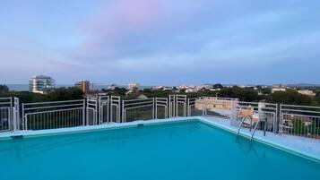 Piscina no terraço com vista para a paisagem urbana.