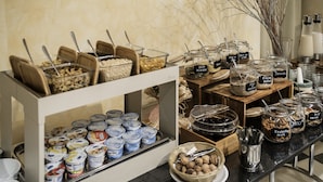 A buffet with various food items including yogurt, granola, and mixed nuts. - Hotel Augustus (Riccione)