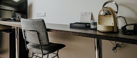 Un espacio de oficina moderno con escritorio, silla y cafetera.