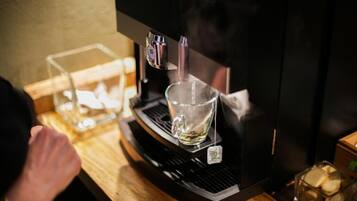 A coffee machine with a glass cup on its drip tray.