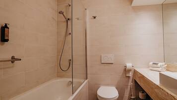 A modern bathroom with a bathtub, toilet, and shower.