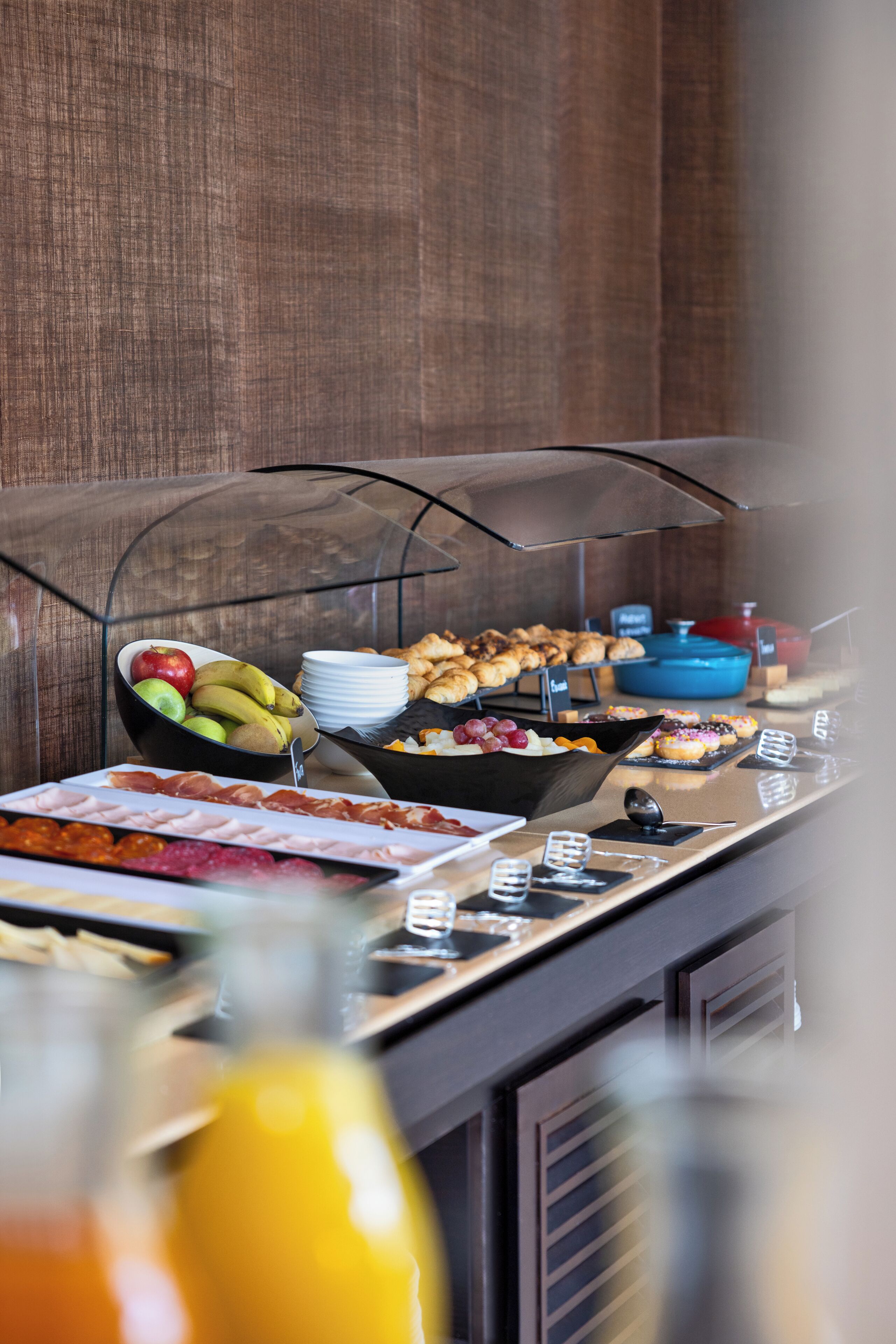 En buffet med forskellige spiser samt et glas appelsinjuice.