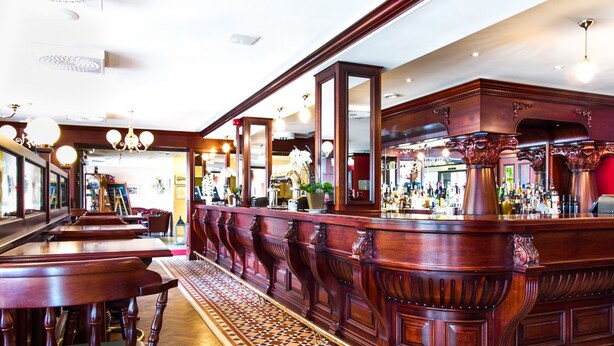 A bar area with wooden furniture and a checkered floor pattern. - Hotell Stinsen (Hallsberg)