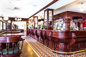 Un área de bar con mobiliario de madera y un suelo a cuadros.