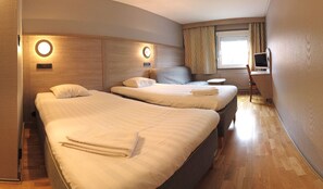 A hotel room with two beds, a TV, and a window with curtains. - Hotell Stinsen (Hallsberg)