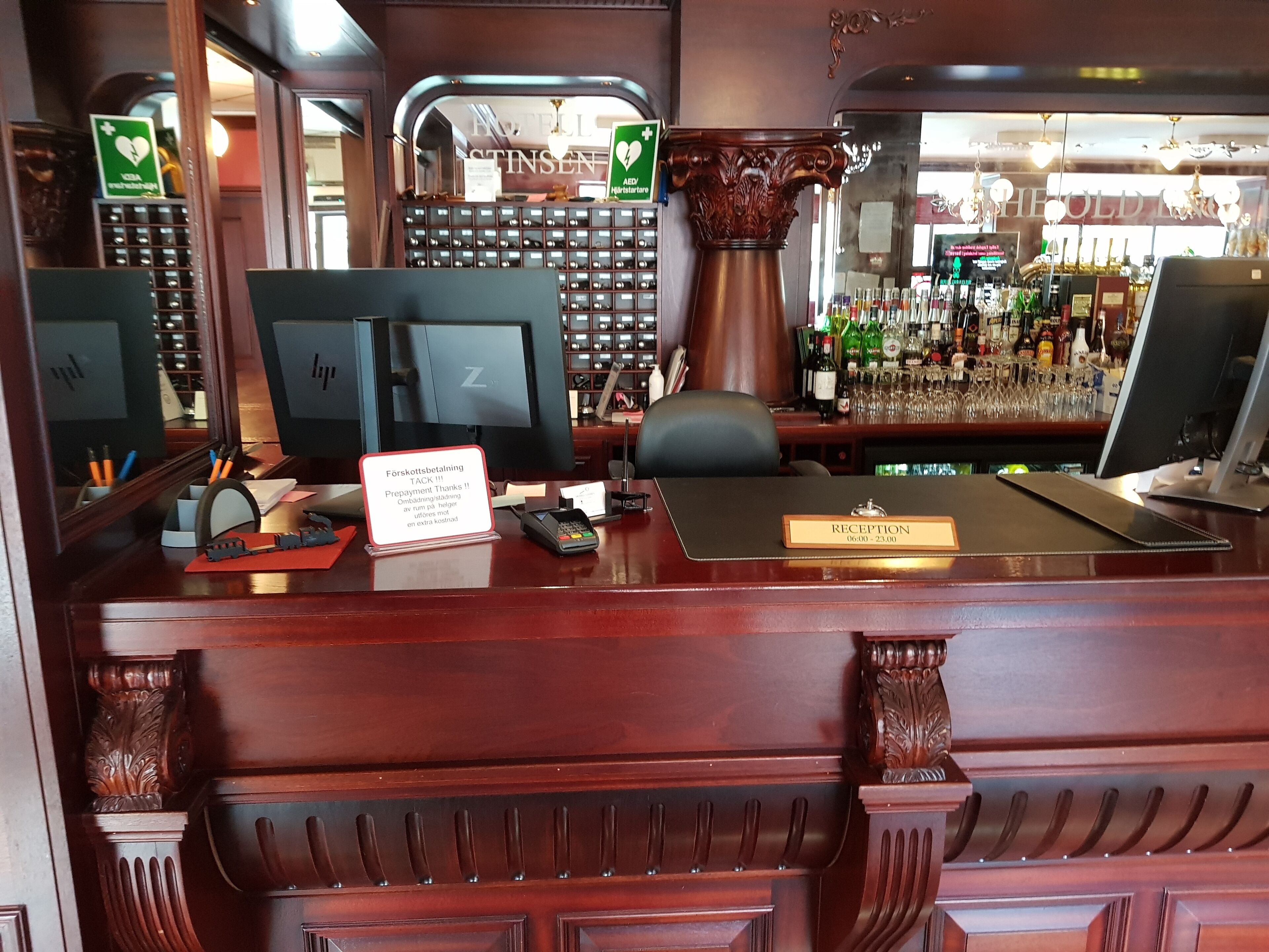 A reception desk with a computer, a cash register, and a sign indicating a prepayment charge.