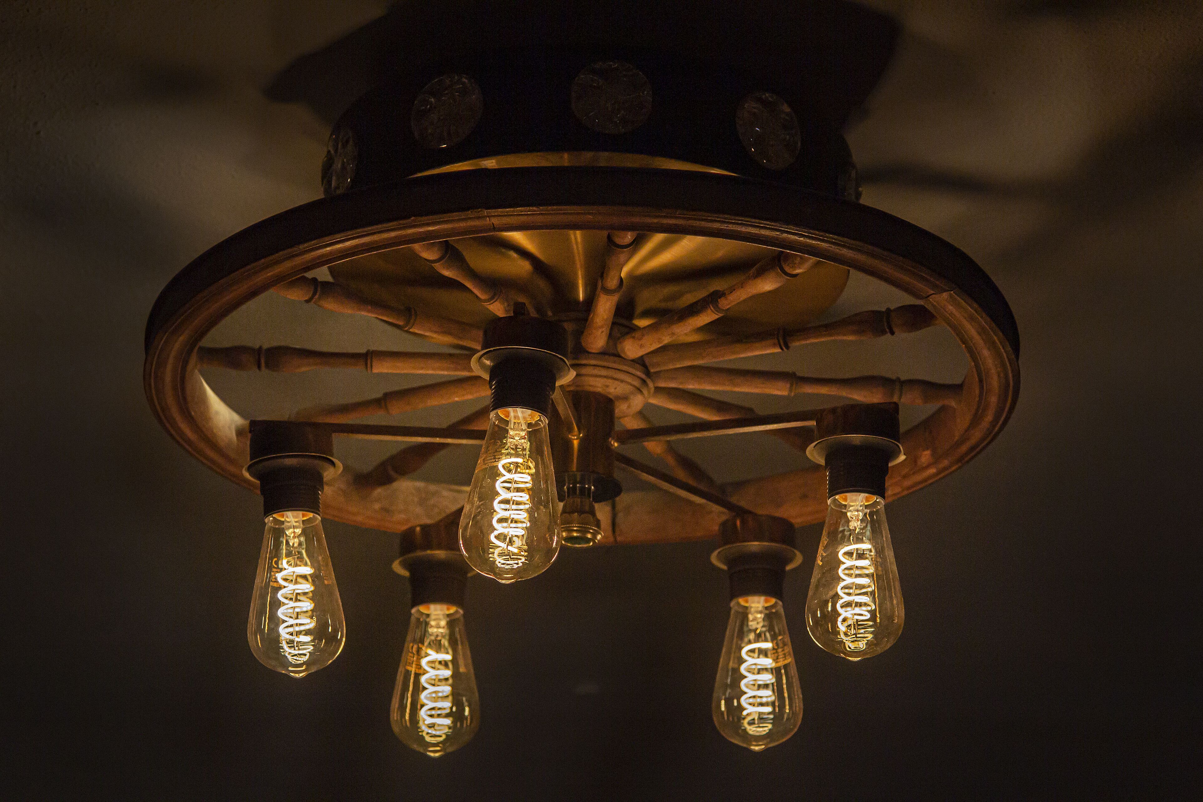 A ceiling with a circular metal frame and four exposed light bulbs.