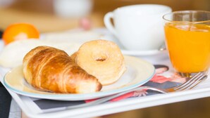 A tray with croissants, a donut, a cup of coffee, and a glass of orange juice. - ibis Firenze Nord Aeroporto (Sesto Fiorentino)