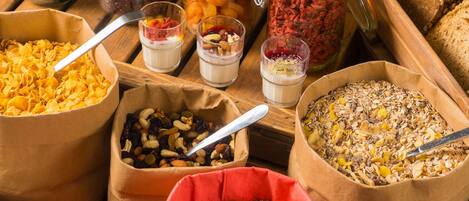 Forskellige madvarer i papirposer og glas, blandt andet tørret frugt, nødder og granola.