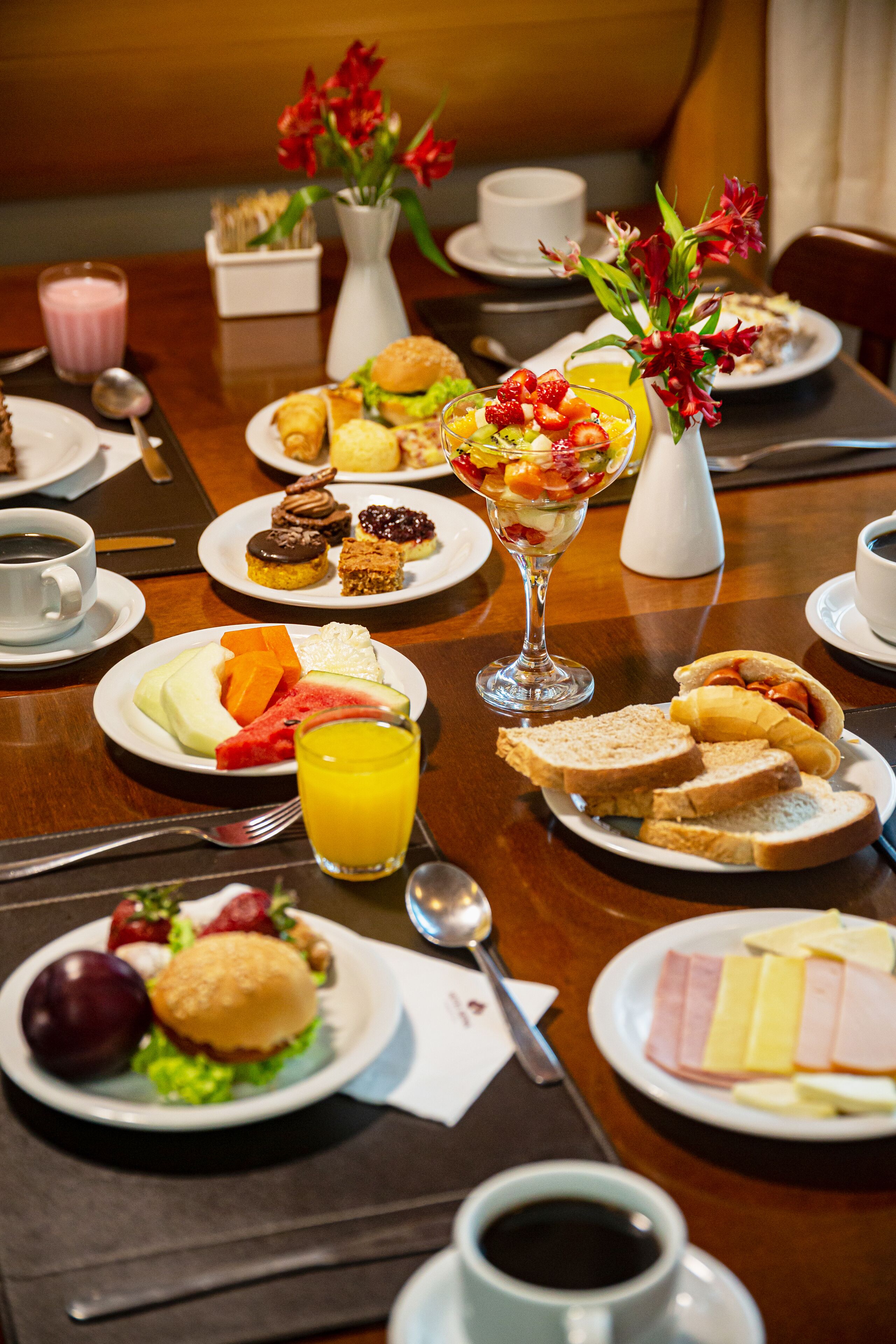 Ein Frühstücksbuffet mit verschiedenen Speisen, darunter Obst, Gebäck und Sandwiches.
