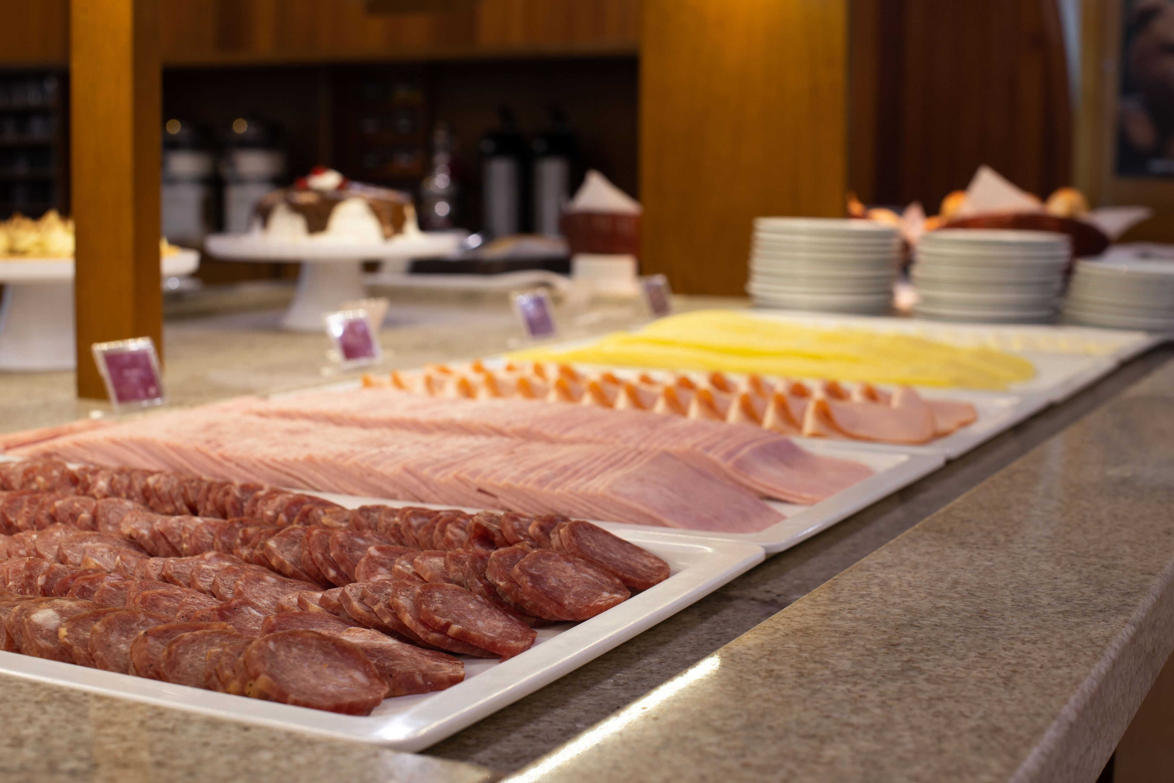 A buffet with various meats and cheeses.