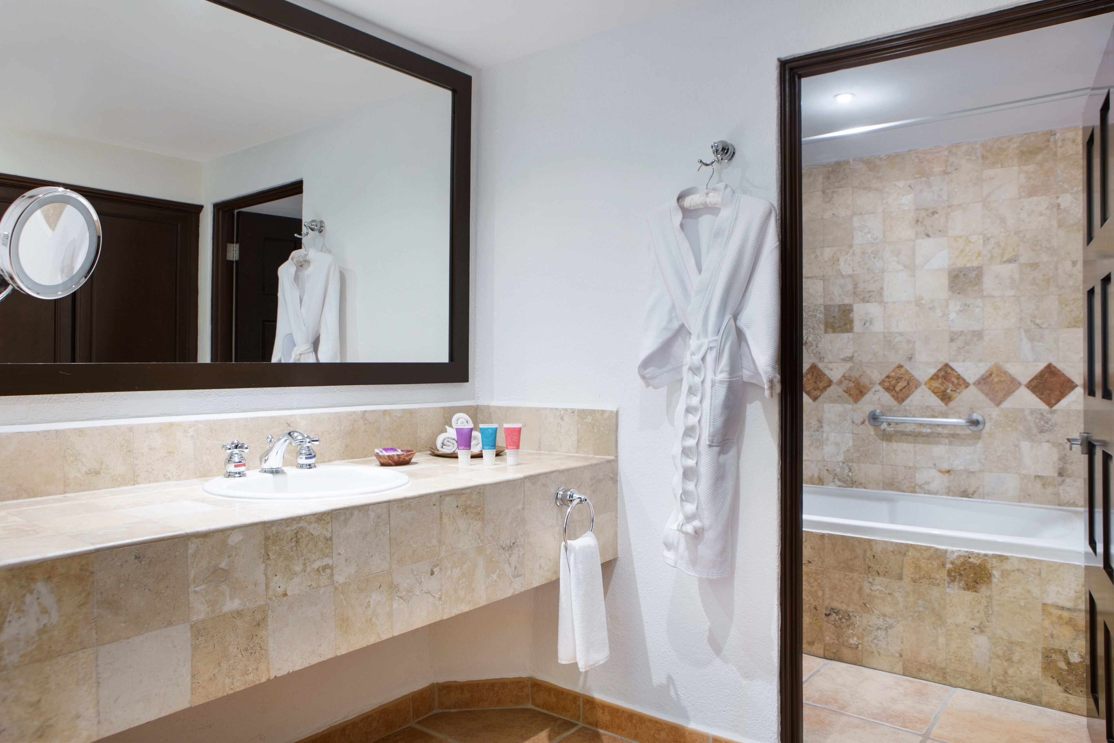 A bathroom with a sink, mirror, and a bathtub.