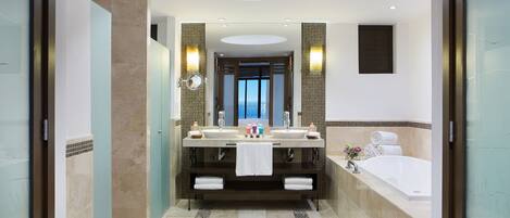 Un baño moderno con lavamanos doble, un espejo grande y una bañera.