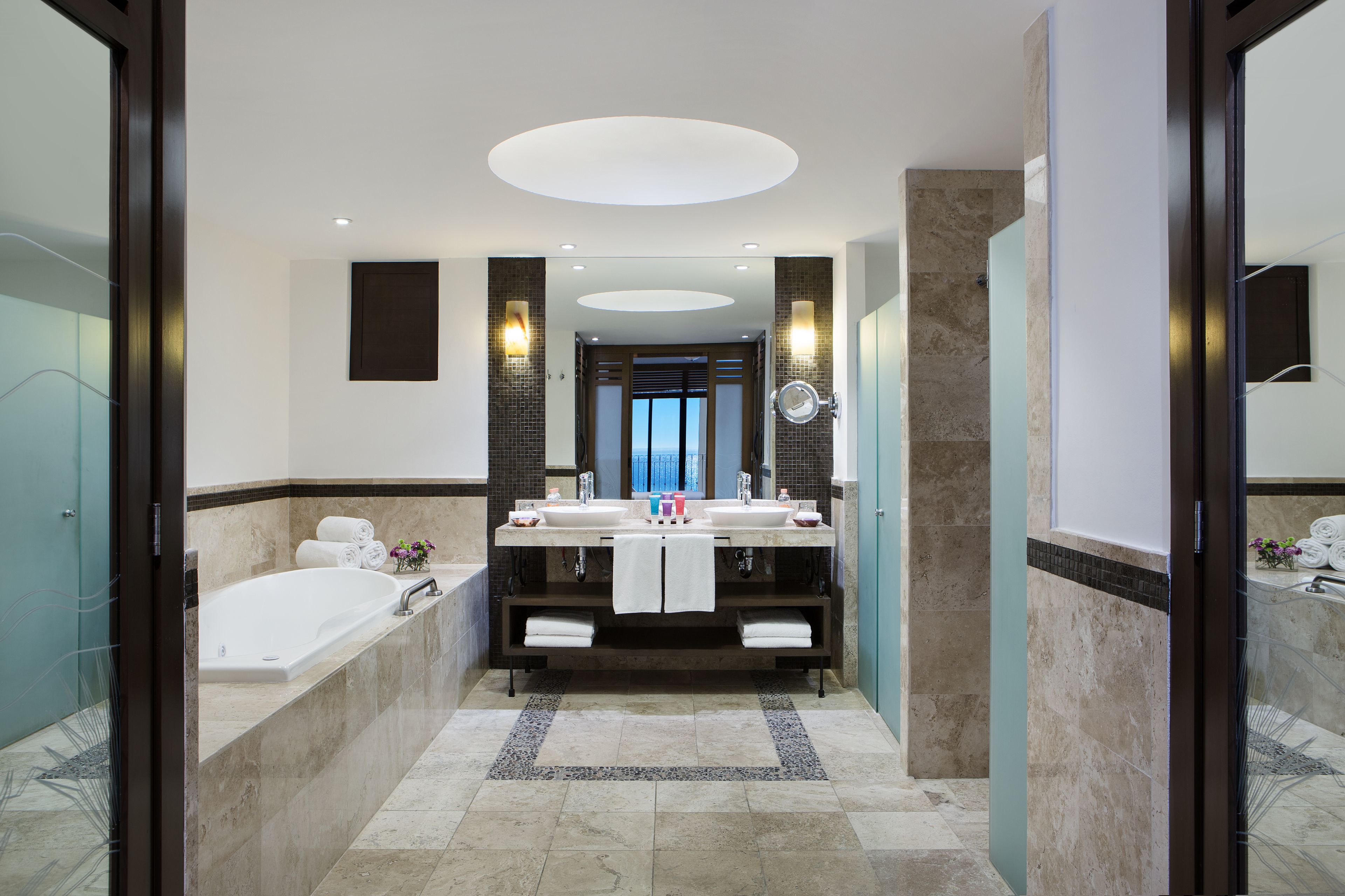 Un bagno moderno con un doppio lavandino, una vasca e uno specchio grande.