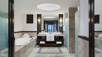 Un bagno moderno con un doppio lavandino, una vasca e uno specchio grande.