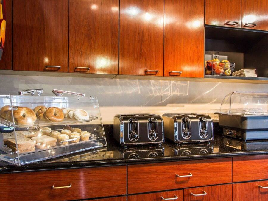 A breakfast buffet with bagels, muffins, and pastries.