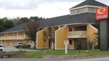 A motel with a yellow facade, a balcony on the second floor, and a sign indicating 'Econolodge'.