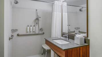 A modern bathroom with a shower, toilet, and sink.