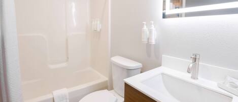 A modern bathroom with a bathtub, toilet, and sink.