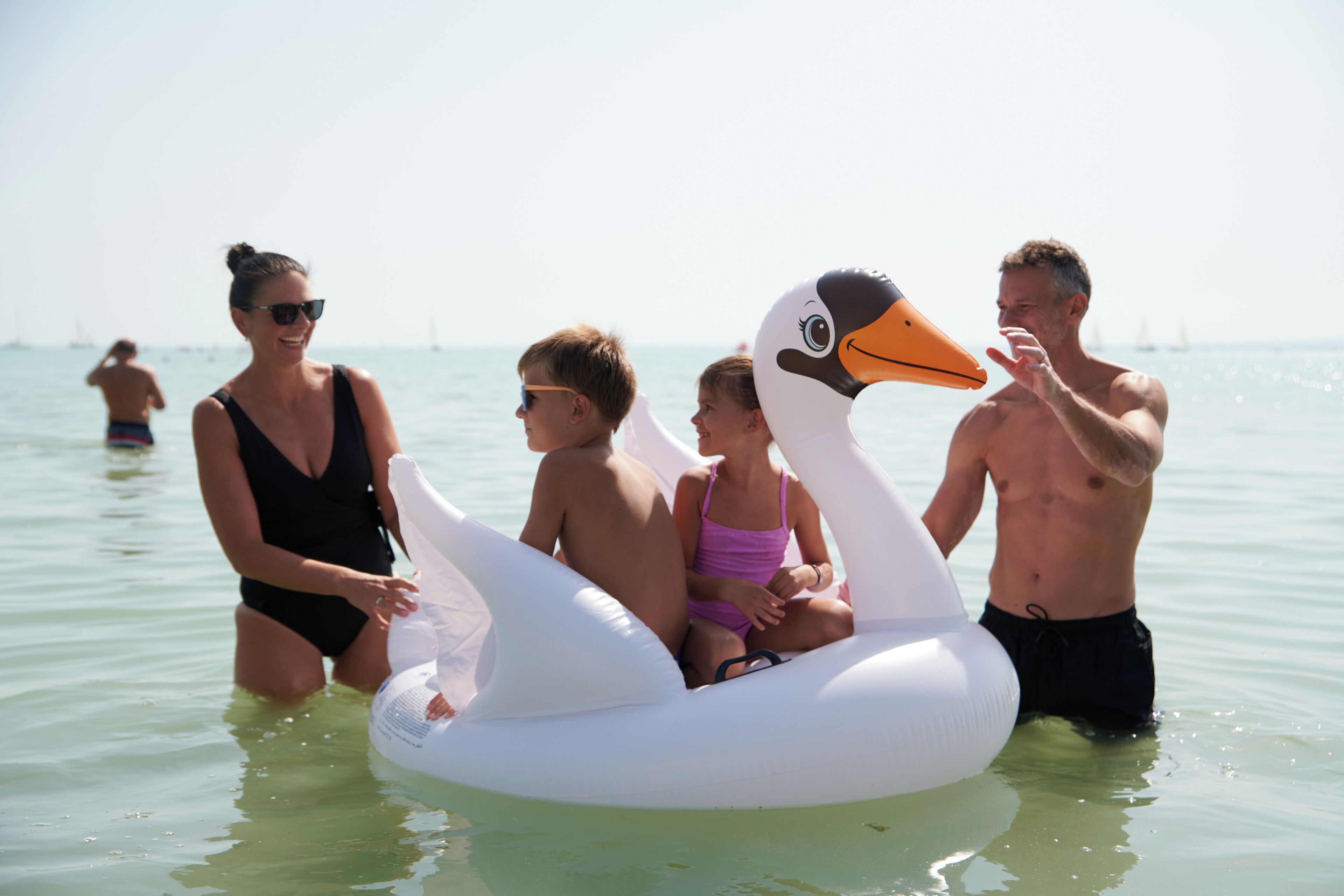A group of people on a water float shaped like a swan.