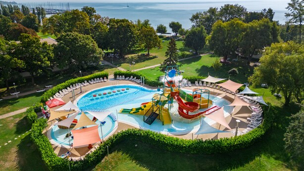 Vue aérienne d’un complexe hôtelier doté d’une grande piscine, de toboggans aquatiques et de chaises longues.