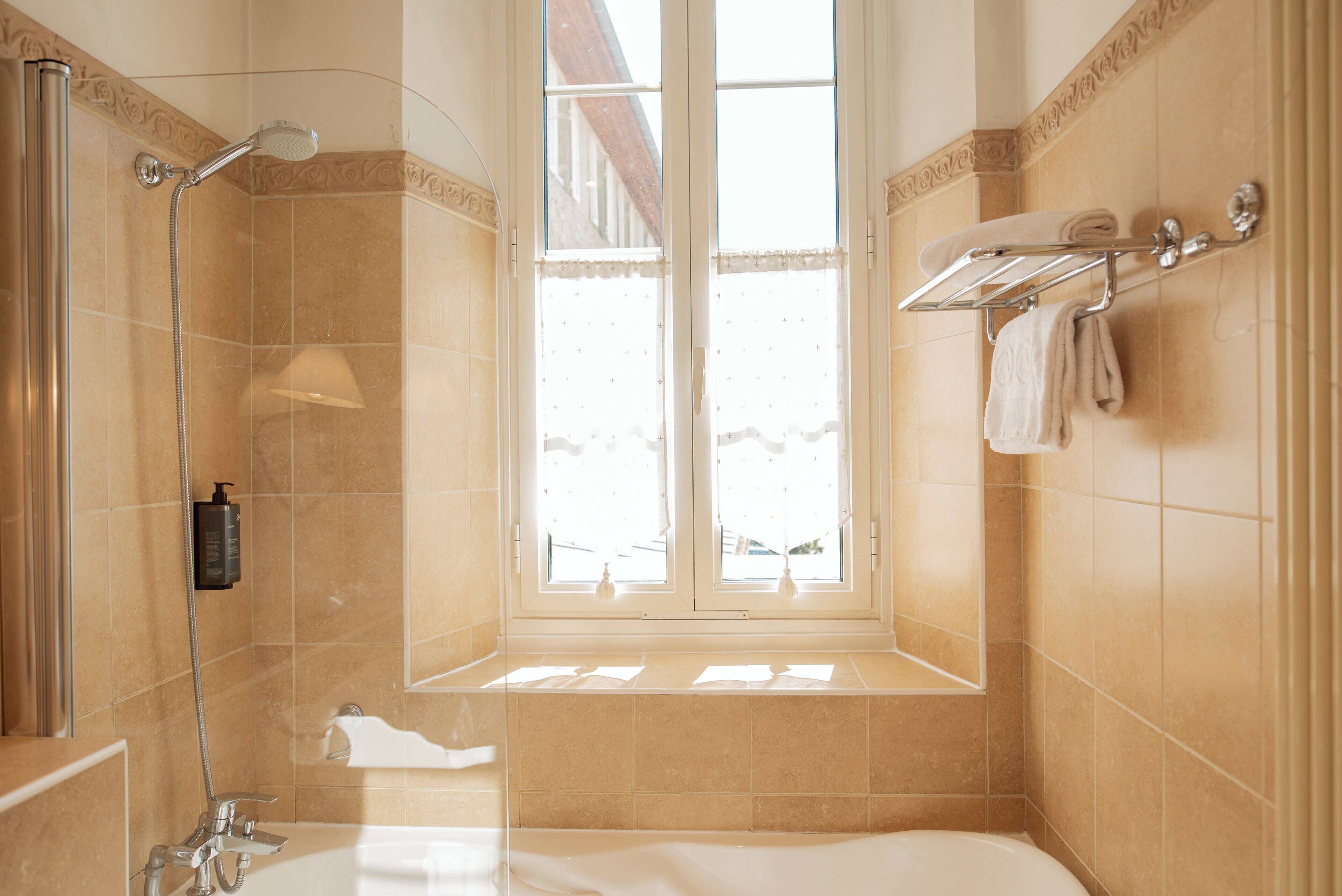 Un baño con bañera, ducha y ventana.