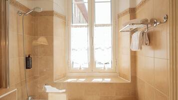 Un baño con bañera, ducha y ventana.