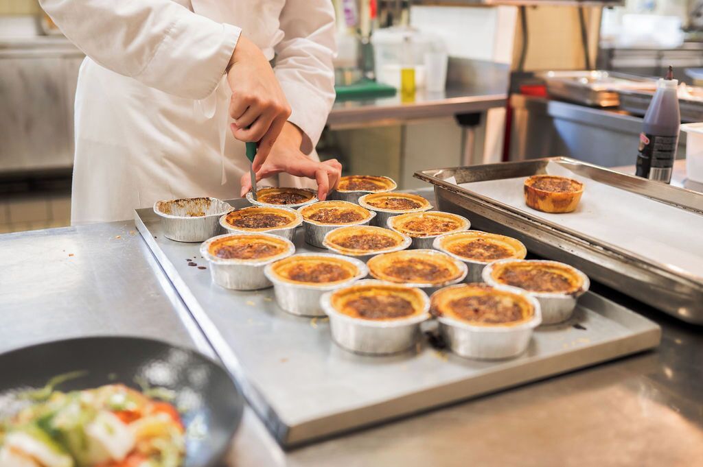 Une cuisine avec plusieurs petits récipients en métal disposés sur un plateau, probablement destinés à la préparation des aliments.