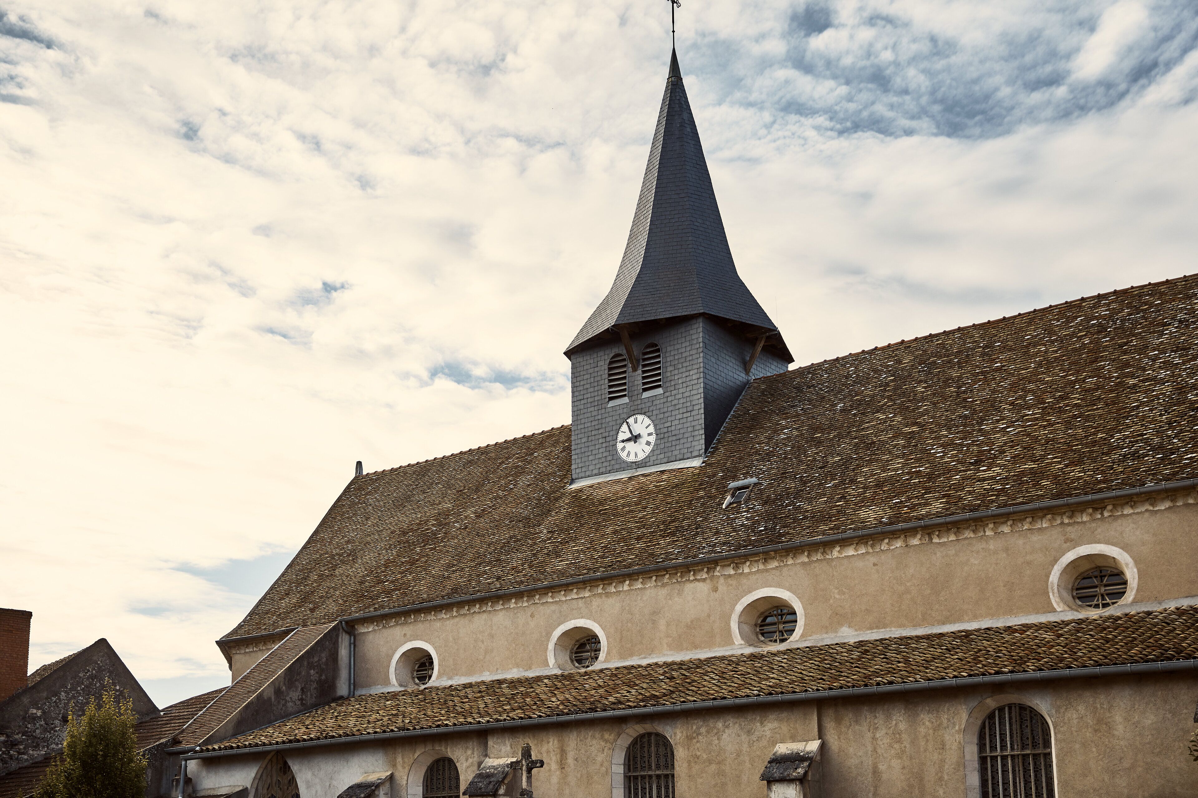A building with a pointed tower and a clock.