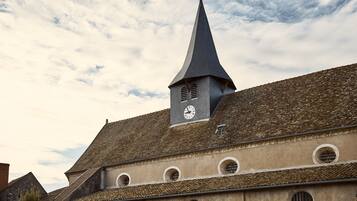 A building with a pointed tower and a clock.