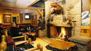 A cozy restaurant with stone walls, a fireplace, and wooden furniture. - Manning Park Resort (Manning Park)