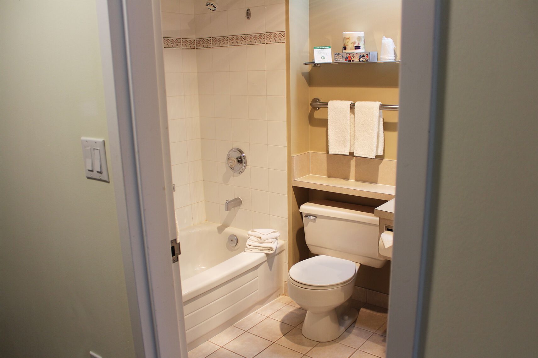 Ein Badezimmer mit Badewanne, Toilette und Ablage für Toilettenartikel.