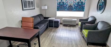 Una sala de estar moderna con un sofá, una mesa y una ventana con cortina de estampado geométrico.