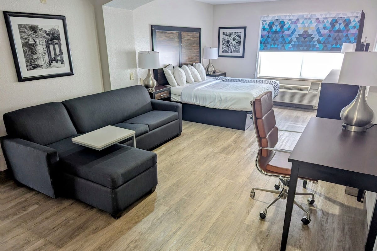Une chambre d’hôtel moderne équipée d’un canapé, d’un lit, d’un bureau et d’une chaise.