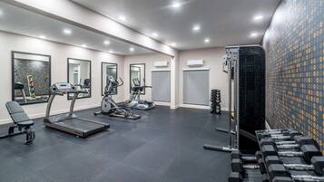 A gym with treadmills, elliptical machines, and free weights.