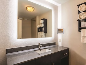Bathroom features a granite countertop sink, a large mirror, and a towel rack.