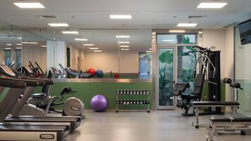 A gym with treadmills, exercise balls, and weight machines.