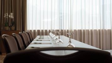 A conference room with a long table, chairs, and wine glasses.