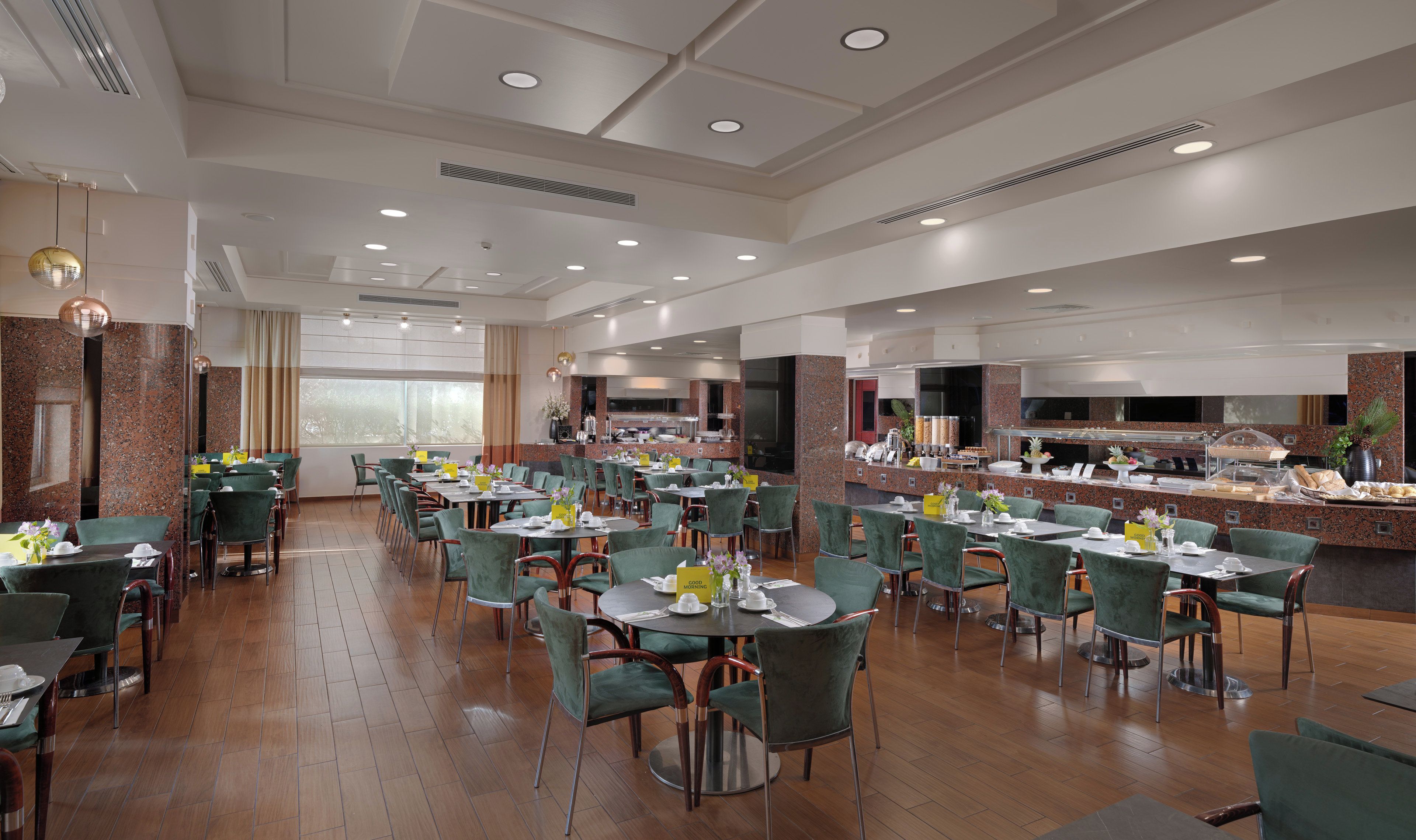 Un grand espace dédié à la salle à manger, avec plusieurs tables et chaises, un buffet et un coin cuisine.